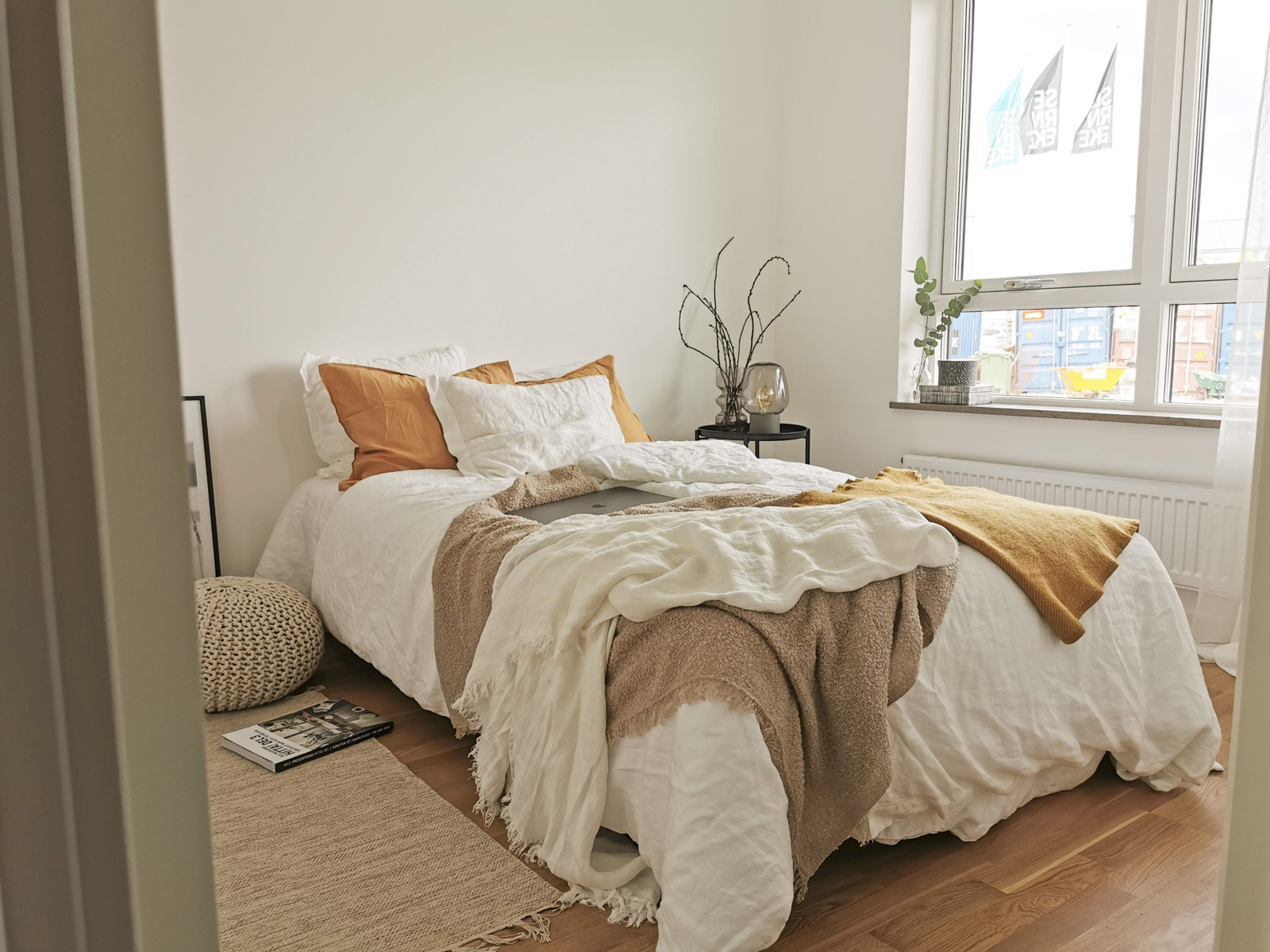 En säng som står i ett sovrum bredvid ett fönster.