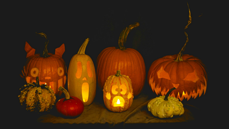 En grupp utskurna pumpor som sitter på ett bord.