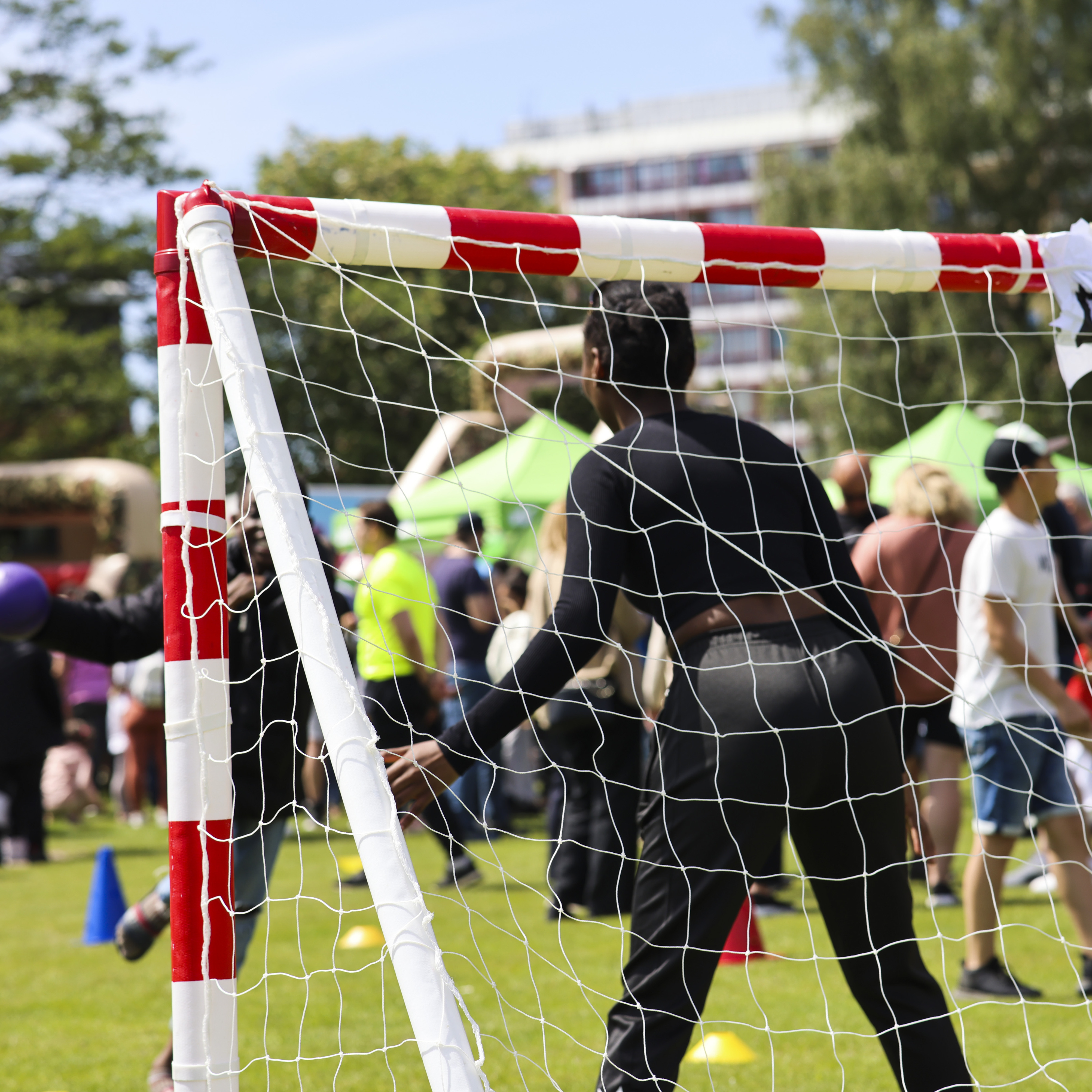 En grupp människor som står runt ett fotbollsnät.