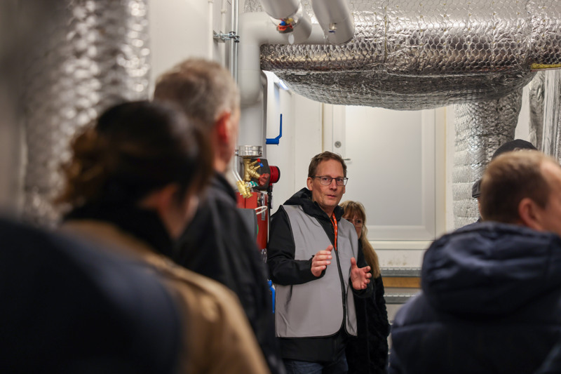 En man står och pratar om ventilation i ett rum.