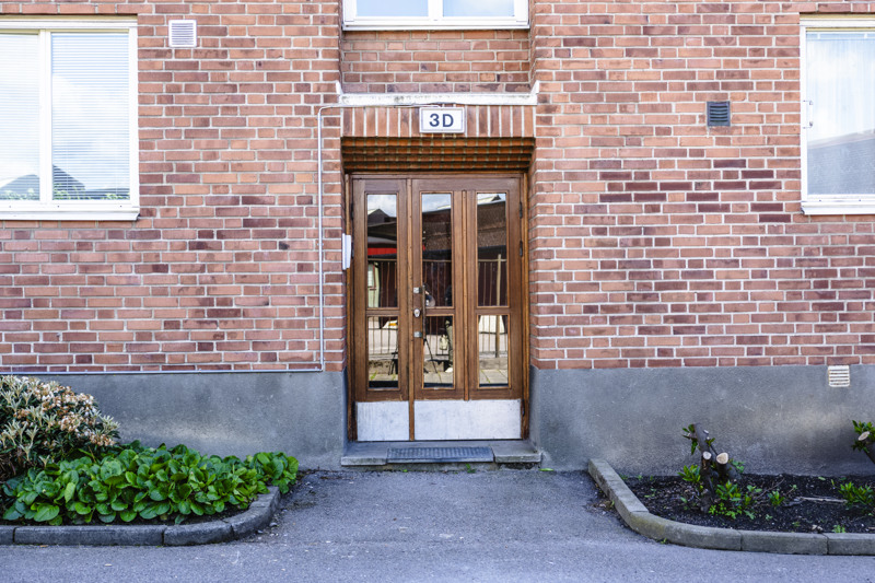 Entrédörr i trä, röd tegelbyggnad