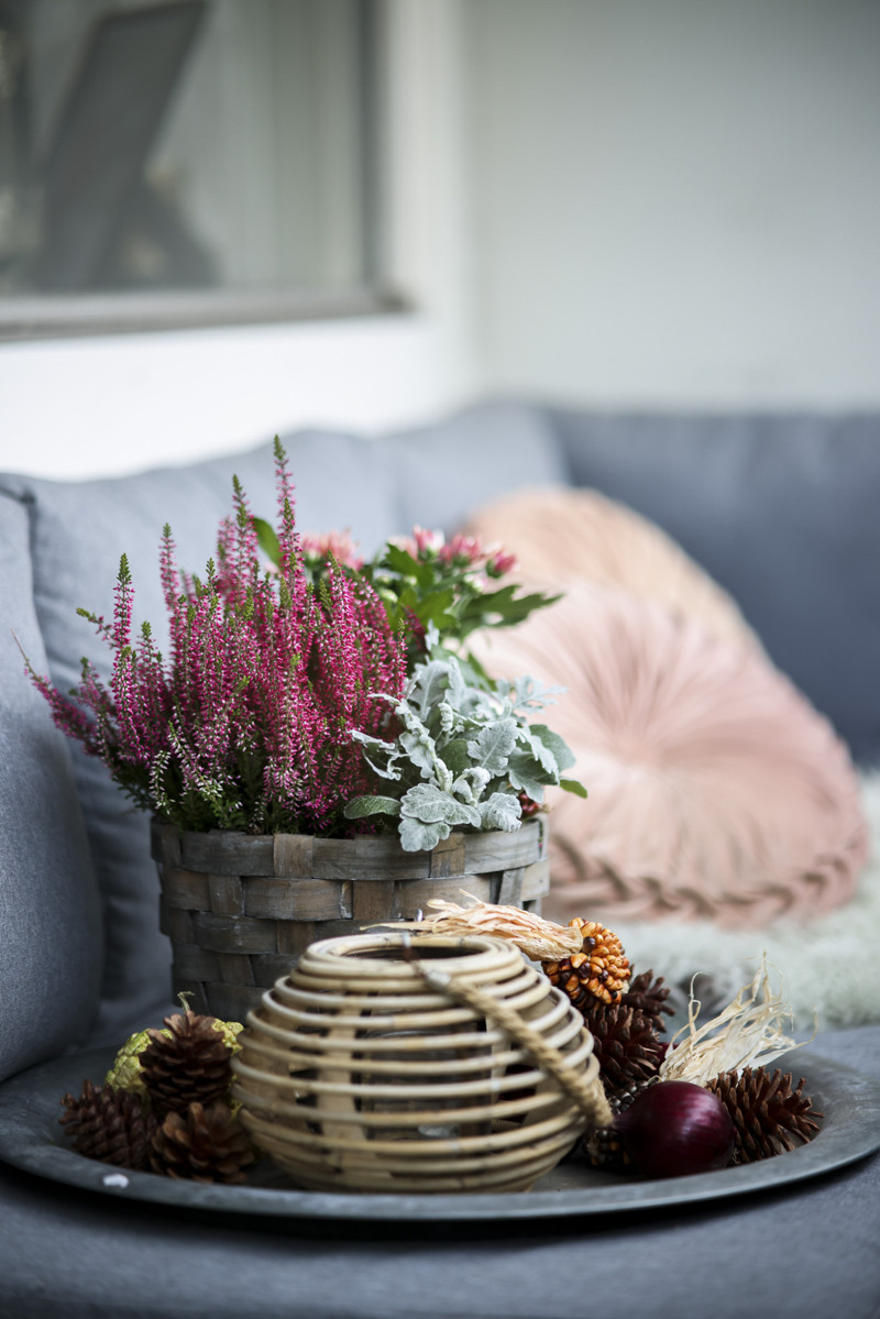 En korg fylld med blommor som står på ett bord.