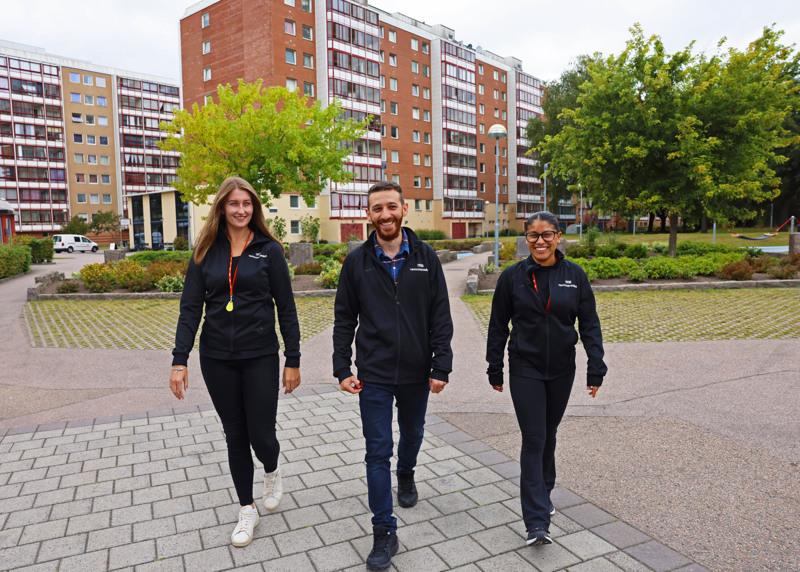 En grupp människor som går längs en trottoar.