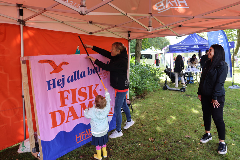 En grupp människor som står under ett tält.