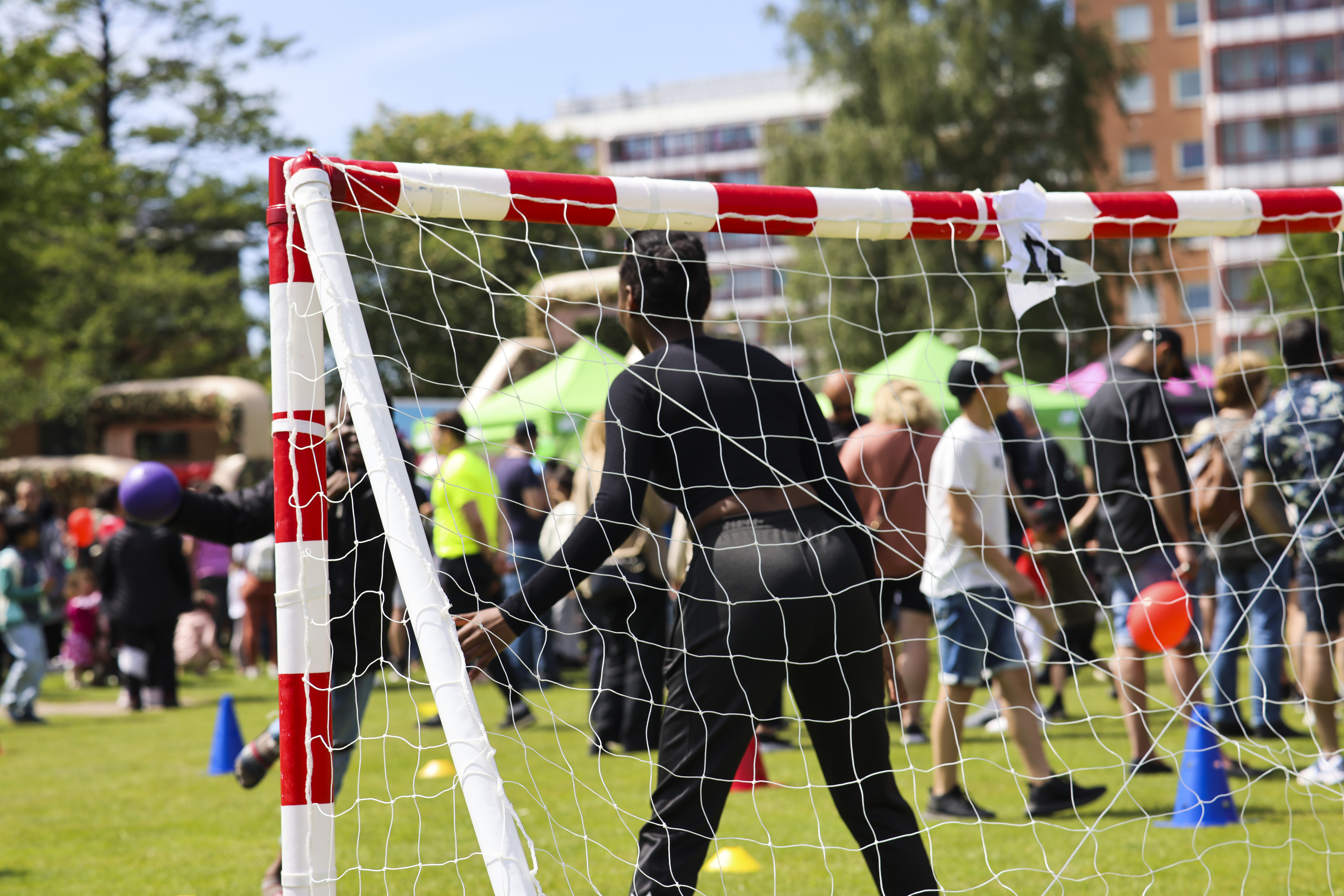 En grupp människor som står runt ett fotbollsnät.