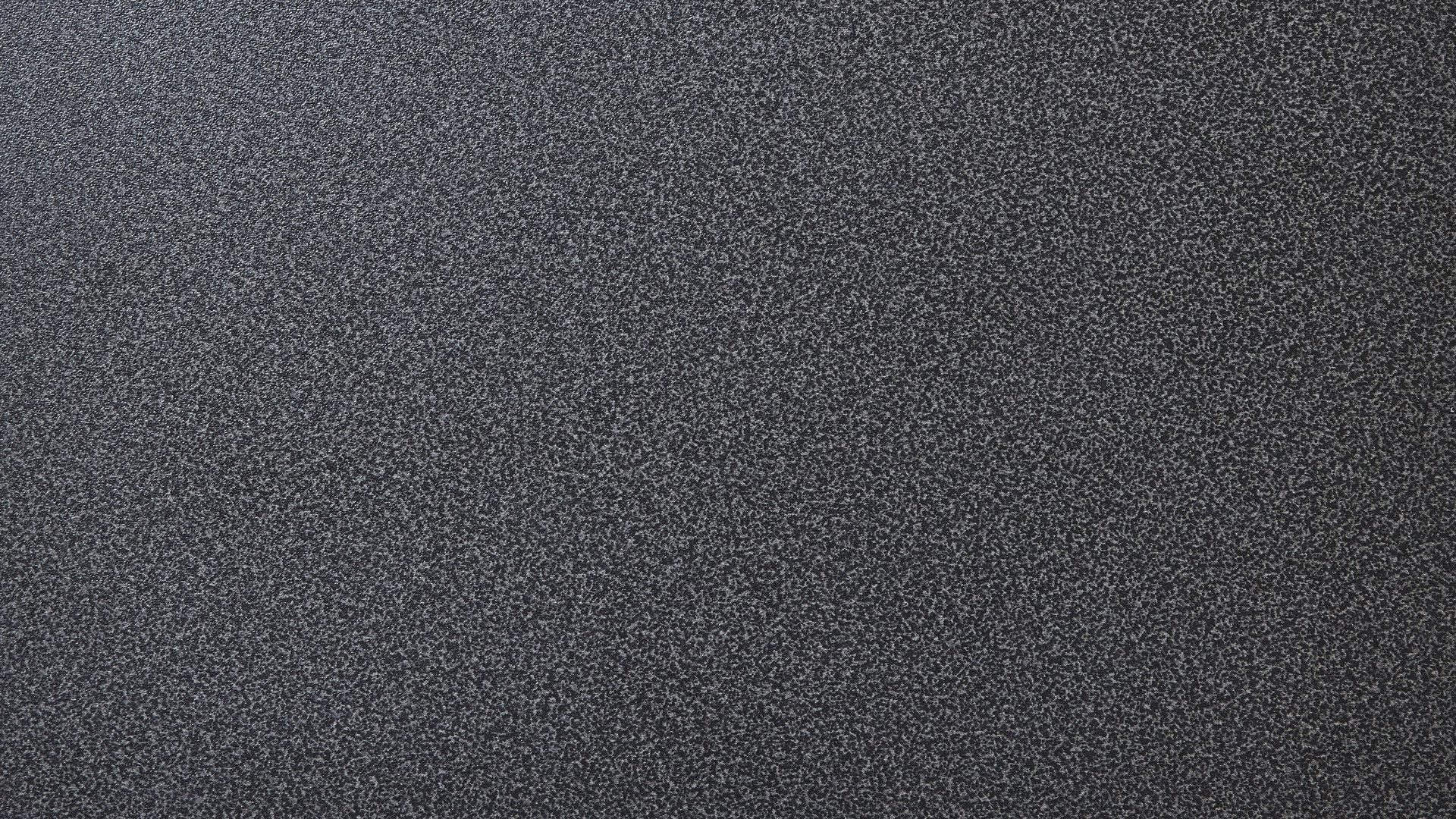 Ett svart fyrkantigt objekt på en vit yta.