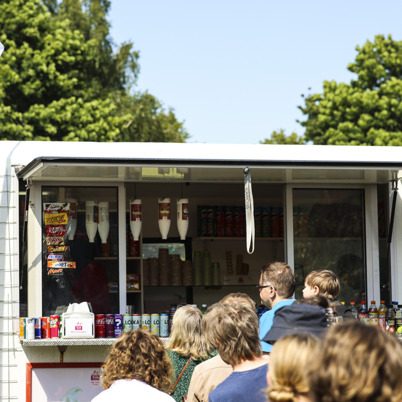 En grupp människor som står framför en food truck.