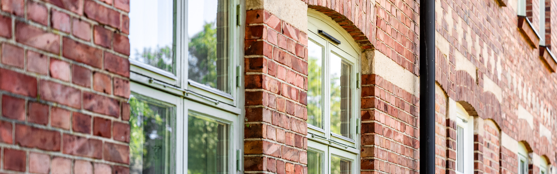 En röd tegelbyggnad med ett vitt fönster.